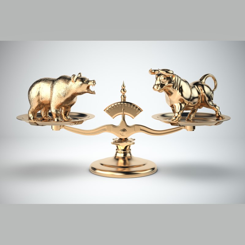 a gold bull and bear representing the market shown even on a balance scale